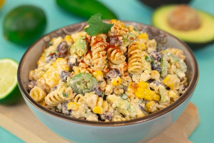 A side-profile shot of the Mind Over Munch recipe Easy Mexican Street Corn Pasta Salad on a blue table.