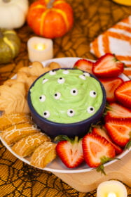 An image of Alyssia's green monster marshmallow dip, covered with candy eyes and surrounded by dippers.