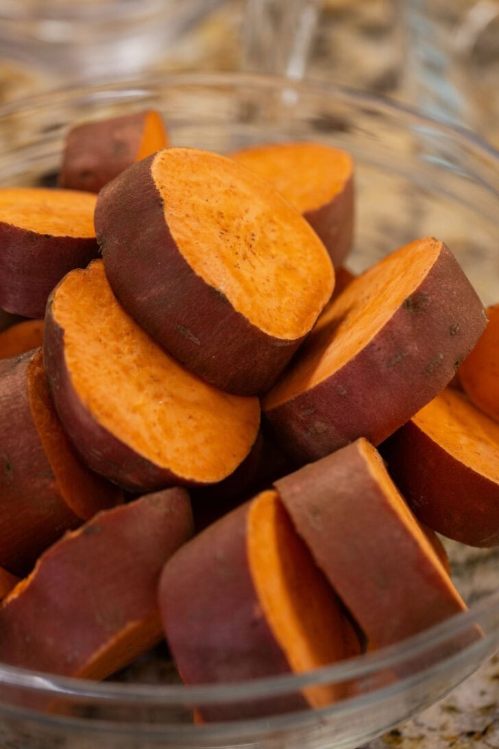 A glass bowl filled with sliced sweet potato rounds.