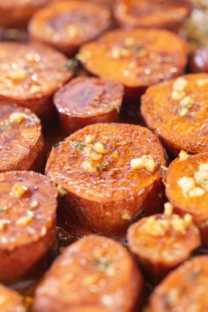 Caramelized rounds of maple brown butter melting sweet potatoes with glaze and herbs