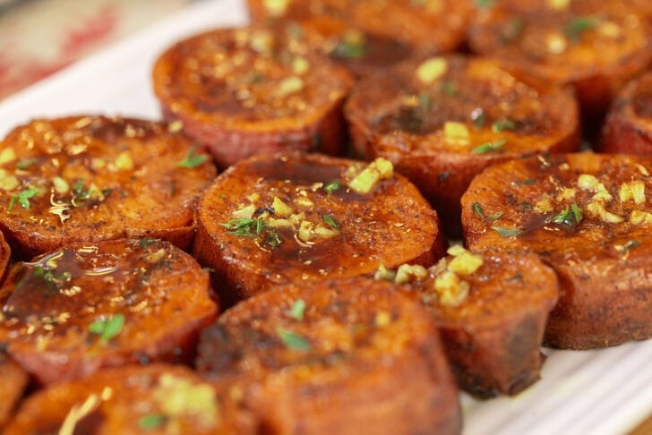 Caramelized rounds of maple brown butter melting sweet potatoes with glaze and herbs