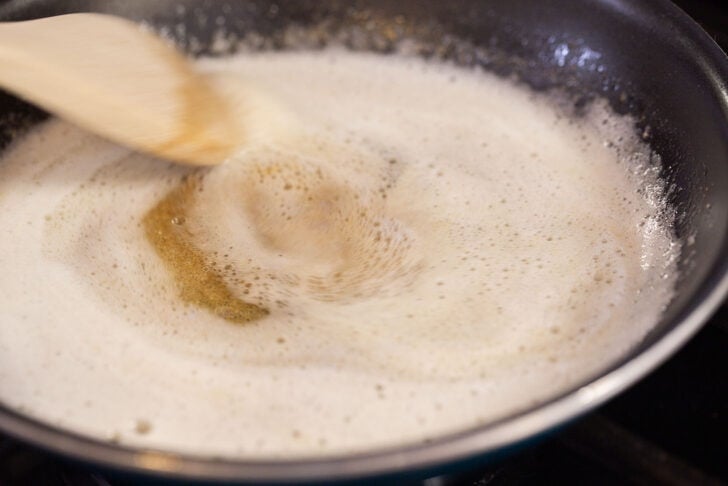 Brown butter being made in a pan over the stove.
