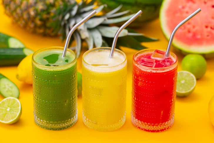 Three glasses of agua fresca, cucumber, pineapple, and watermelon flavors.