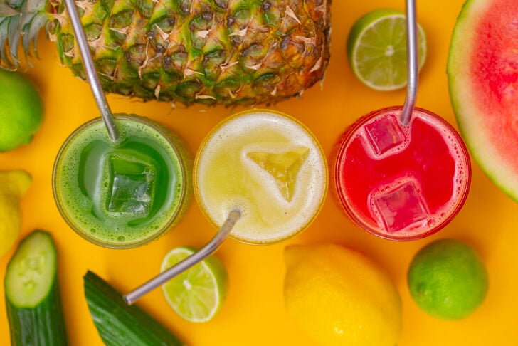 Three glasses of agua fresca lined up in a row, cucumber, pineapple, and watermelon flavors.