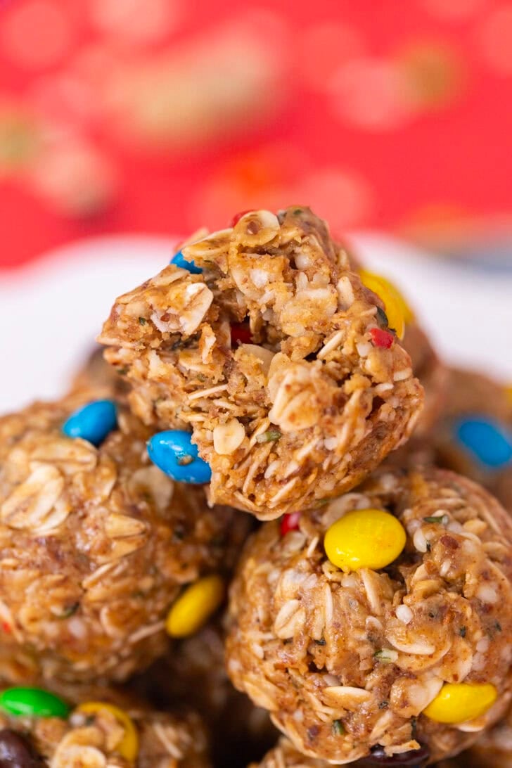 A close-up of a no-date protein ball on a white plate, sitting on a red table setting.