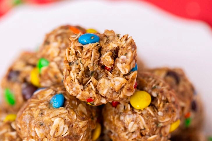 A close-up of a pile of no-date protein balls on a white plate, sitting on a red table setting.