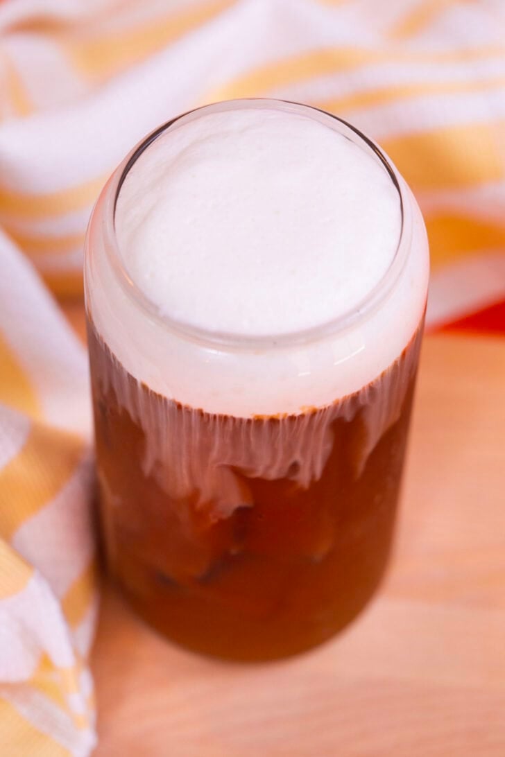 A glass of iced coffee topped with vanilla sweet cream cold foam.