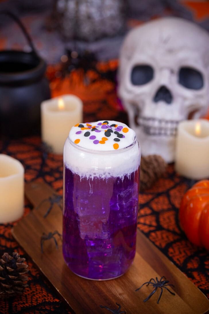 A halloween themed witch's brew dirty soda on a table with halloween decorations
