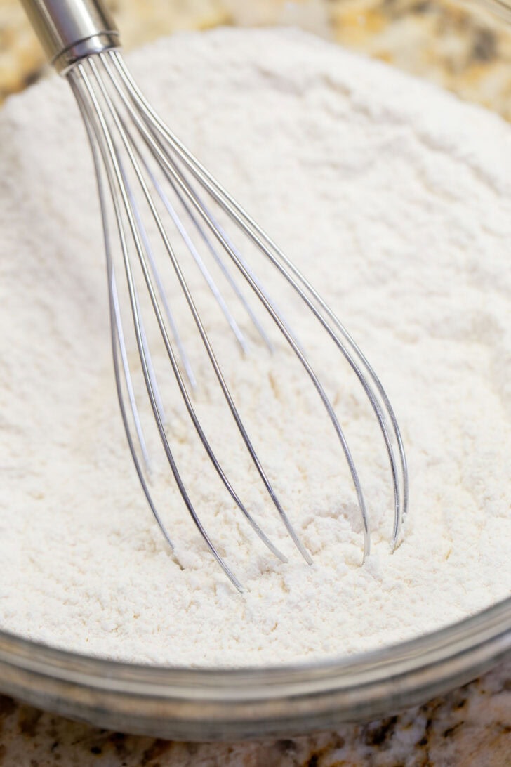 Whisking flour, cream of tartar, baking soda, and salt together in a glass bowl.