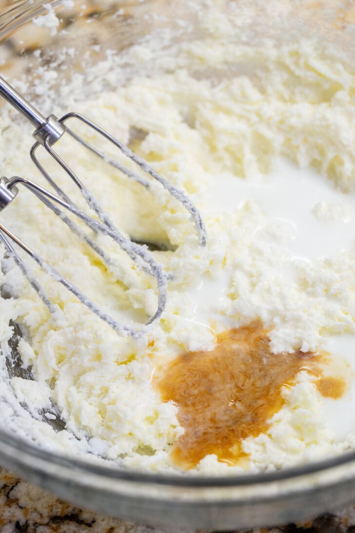 Milk and vanilla extract added to creamed butter and sugar for eggless snickerdoodle dough.